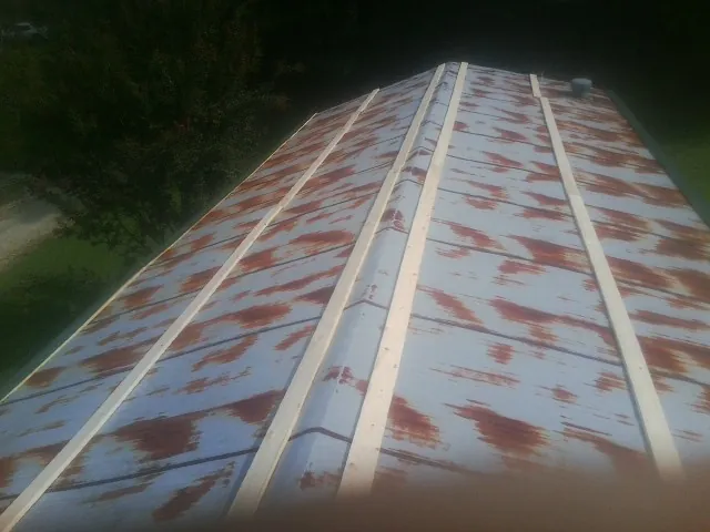 Rusted metal roof panels with new wood purlins before replacement — Storm Damage Roof Repair in Eldon by Roofing Brothers