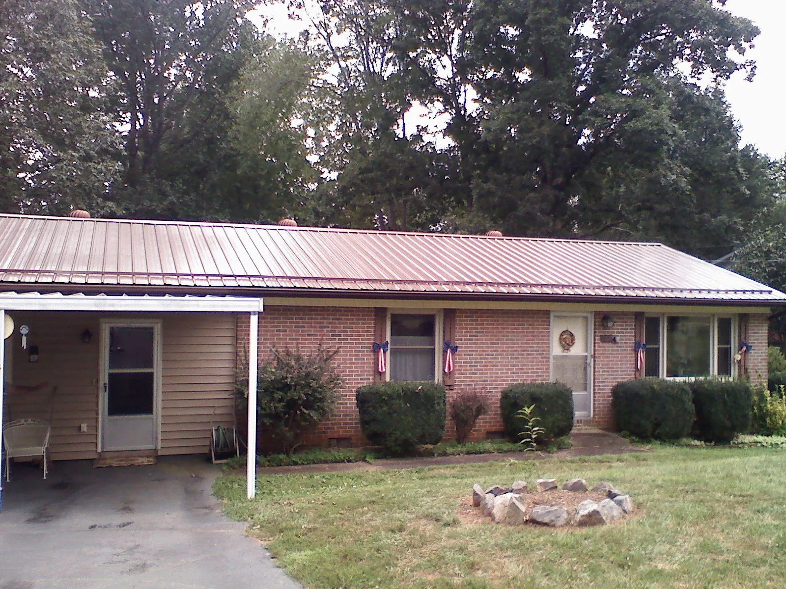 Bronze metal roof and carport on a brick ranch home — Roof Repair work by our crew in Eldon